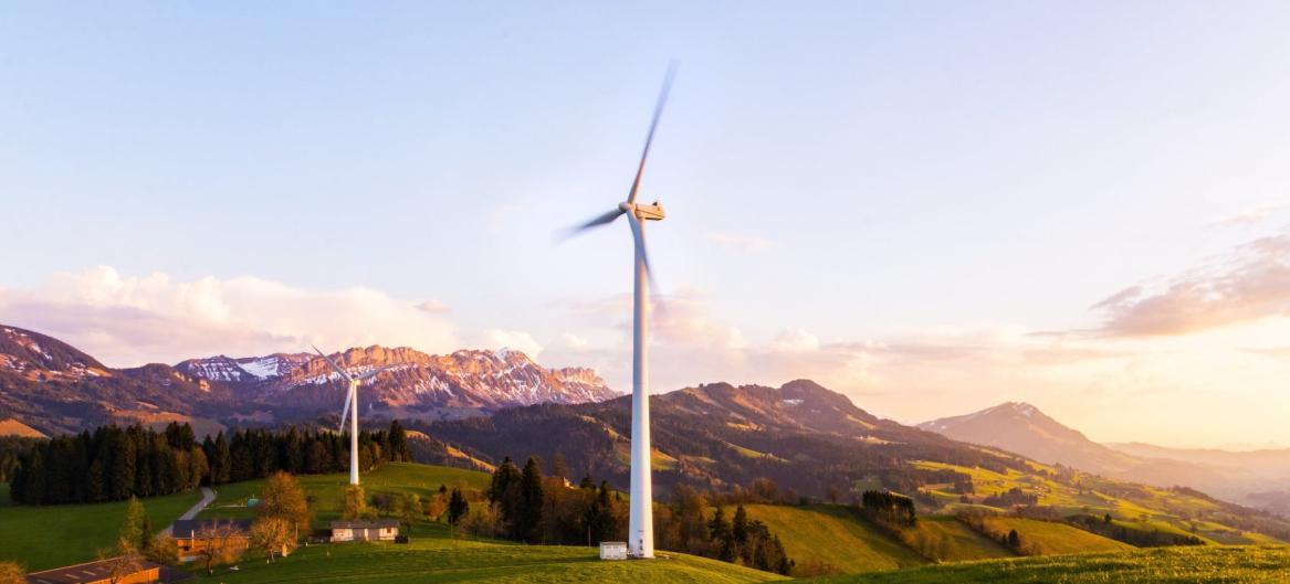 wind turbine in the middle a plain in front of mountains